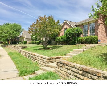 Single-family Home With Brick And Stone Elevation Above Street Level In Irving, Texas, USA. Lush Landscaping Neighborhood With Concrete Walking Biking Trail. Terrain House On Elevated Lots