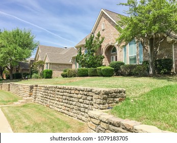 Single-family Home With Brick And Stone Elevation Above Street Level In Irving, Texas, USA. Lush Landscaping Neighborhood With Concrete Walking Biking Trail. Terrain House On Elevated Lots