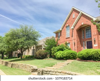 Single-family Home With Brick And Stone Elevation Above Street Level In Irving, Texas, USA. Lush Landscaping Neighborhood With Concrete Walking Biking Trail. Terrain House On Elevated Lots