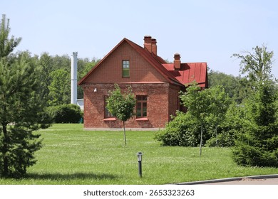 A single-story red brick house surrounded by a lush green field, perfect for rural or countryside scenes.