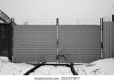 a single-track railway blocked by an iron fence and barbed wire. - Powered by Shutterstock