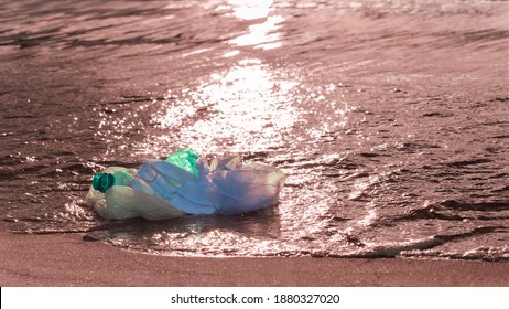 Single-use plastic waste - medical mask, plastic bottle and bags by ocean. World ocean pollution. Ecology, climate crisis, environmental issues concept. Selective focus, banner, copy space - Powered by Shutterstock