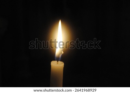 Singular candle with a dark background