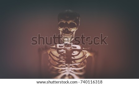 Sinister looking skeleton lit from below with a red glow.