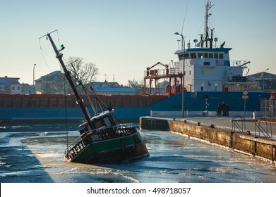 SINK BOAT IN THE HARBOR. The Ship Enters A Port Near The Sinking Boat