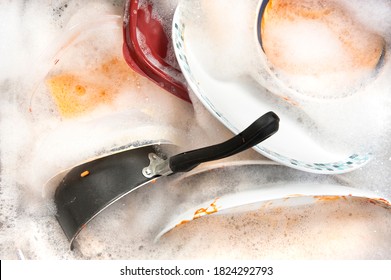 A Sink Full Of Dirty Dishes And Soapy Water.