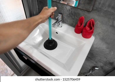 Sink repair by hand with a Toilet Plunger. Plumbing. A plumber uses a plunger to unclog a sink. Toilet Plunger.