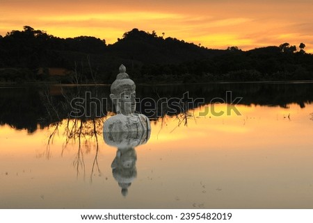 Sinking Buddha statue (Drowning Buddha) and reflectiom.
A largeBuddha statue in the middle of the lake. 
Phra Phuttha Siri Phuwadon Mongkonchai,
Khao Ra-Kham reservoir ,Trat province,Thailand 