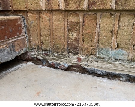 Sinking concrete foundation in need of mudjacking leveling repair. Sunken cement slab porch.