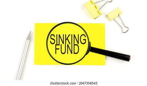 SINKING FUND Text On The Sticker Through Magnifier. View From Above. Business