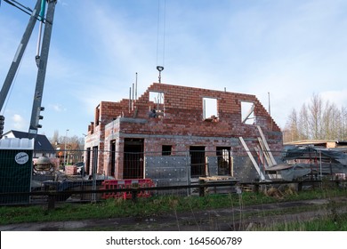 Sint Gillis Waas, Belgium, February 12, 2020. The Side Of A House Under Construction, There Is Used Red-brick, All Protected By An Iron Fence