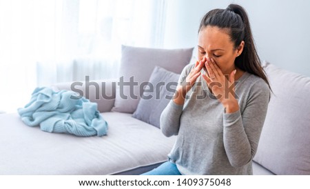 Sinus ache causing very paintful headache. Unhealthy Asian woman in pain. Sharp strong sore. Sinus pain, sinus pressure, sinusitis. Sad woman holding her nose and head because sinus pain