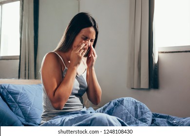 Sinus pain, sinus pressure, sinusitis. Sad woman holding her nose and head because sinus pain. Sinus ache causing very paintful headache.