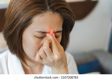 Sinus,Sinusitis, or rhinosinusitis concept. Asia woman suffer from headache, thick nasal mucus, and face pain symptoms. - Shutterstock ID 2107208783