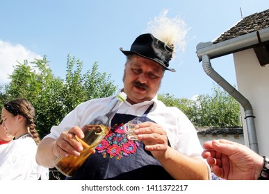 Sioagard, Hungary - August 14, 2018: Magyar Man In National Folk Costume With A Bottle Of Wine In Hands,Wine Tasting For Tourists,  Siogard Village, Hungary