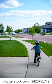 Sioux Falls, South Dakota, USA - 6/2019:  Young Boy Riding A Bike In A Neighborhood