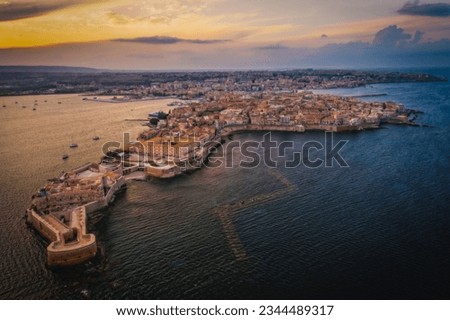 Siracusa, Ortigia Island from the air at sunset, Sicily, Italy. Isola di Ortigia, coast of Ortigia island at city of Syracuse, Sicily, Italy. Aerial view. June 2023