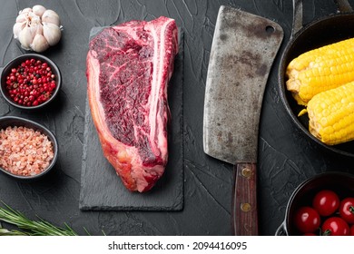 Sirloin beef meat marbled steak set, Club steak cut, on stone board , with old butcher cleaver knife, on black stone background