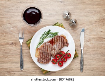 Sirloin Steak With Rosemary And Cherry Tomatoes On A Plate With Wine. View From Above