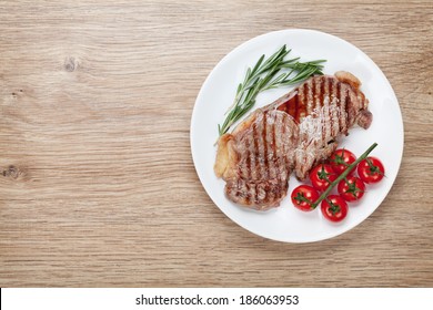 Sirloin Steak With Rosemary And Cherry Tomatoes On A Plate. View From Above With Copy Space