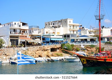 SISSI, CRETE - SEPTEMBER 14, 2016 - Black Rose Pirate ship moored in the harbour with waterfront restaurants to the rear, Sissi, Crete, Europe, September 14, 2016.