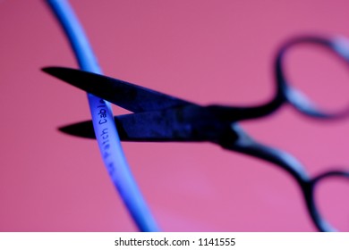 Sissors cutting a blue cable