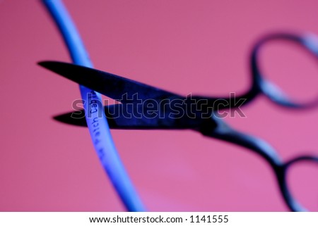 Sissors cutting a blue cable