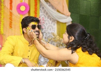 Sister applying haldi on grooms face in  traditional hindu marriage ritual