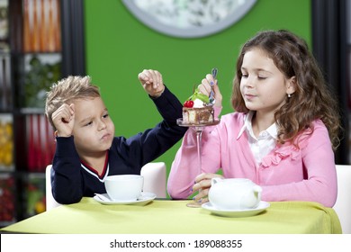 Sister And Brother Enjoying Meal Sitting At Restaurant Table 