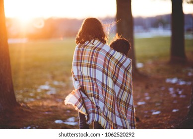 Sister And Brother Wrapped In A Blanket Trying To Stay Warm On A Cold Day Outdoors