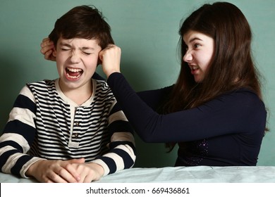 sister pull brother ear as a loss in argument wage close up photo - Powered by Shutterstock