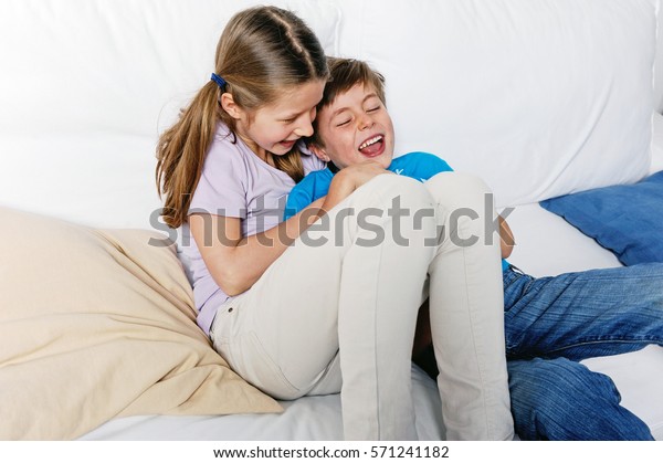 Sister Tickling Her Ticklish Brother Home Foto De Stock 571241182