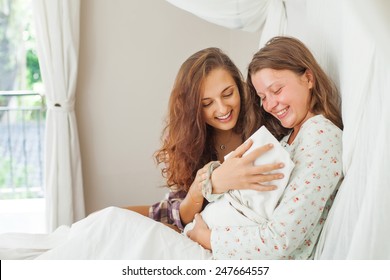 sister visiting a young mother with her newborn infant in clinic - Powered by Shutterstock