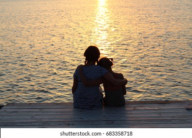 Sisters With Arms Around Each Other At Sunset