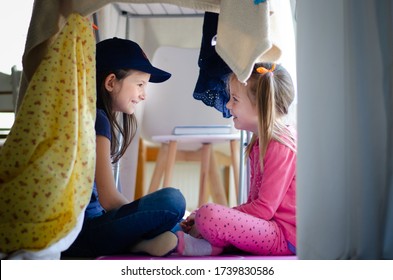 Sisters Bonding And Having Fun Indoors In Blanket House Or Pillow Fort