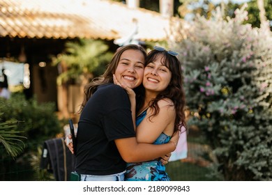 sisters and friends hugging each other smiling in summer