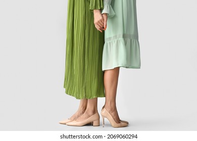 Sisters Holding Hands On Grey Background