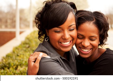 Sisters hugging and smiling.