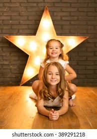 The sisters posing in the studio next to the star ligter
