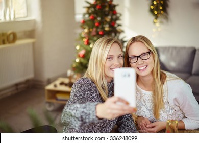 sisters taking a selfie while having christmas dinner at home Stock Photo