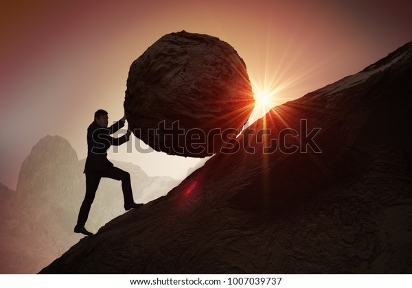 Sisyphus metaphore. Silhouette of businessman\
pushing heavy stone boulder up on\
hill.