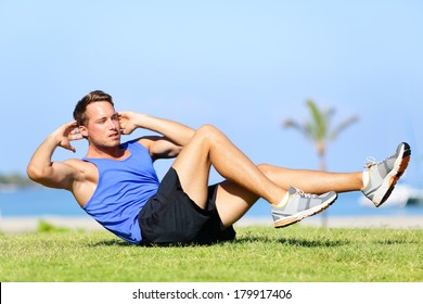 Sit Ups - Fitness Man Exercising Sit Up Outside In Grass In Summer. Fit Male Athlete Working Out Cross Training In Summer. Caucasian Muscular Sports Model In His 20s.