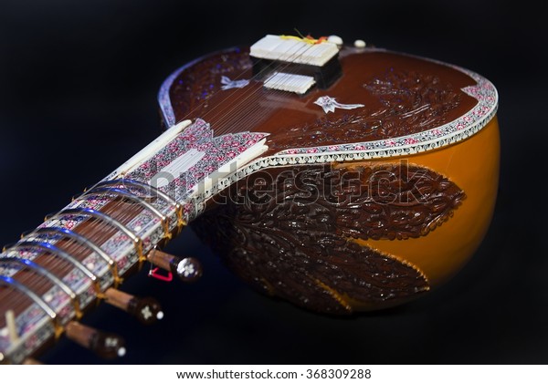 Sitar, a String Traditional Indian Musical\
Instrument, close-up, blue lens effect. dark background. Evening of\
ethnic oriental music. Indian\
Raga