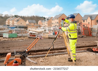 Site engineer in hi-viz installing surveying instrument on construction site