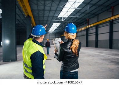 Site Inspector Consulting With Construction Worker