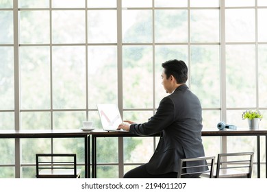 Site View Of Mature Asian Business Man Working With Laptop Computer At The Office Work