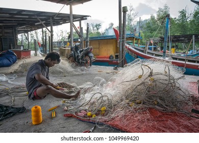 Sitiawan, Perak, Malaysia. March 11, 2018: Fisherman Knitting His Fishing Net.