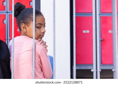 Sitting alone, african american girl looking thoughtful near school lockers, feeling isolated. Loneliness, contemplation, solitude, adolescence, reflection, introspection - Powered by Shutterstock