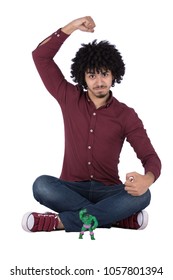 Sitting Man Crossed Legs And Hulk Toy On The Front Of Him, Raising An Arm And Showing Biceps Like The Toy, Isolated On A White Background.