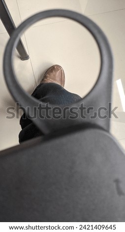 I'm sitting on a chair, why is there a kind of target scope on the chair pointing at the feet that are wearing brown leather shoes?